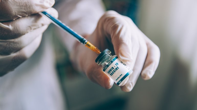 Arzt zieht Spritze mit neuem Novavax Impfstoff auf.