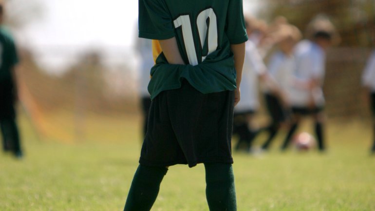 Das Bild zeigt ein Kind, das Fußball spielt.