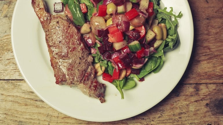 Das Bild zeigt einen Teller mit Gemüse und Fleisch. 