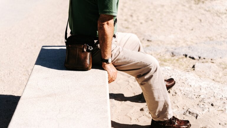 Ein Mann sitzt auf einer Mauer und ruht sich aus