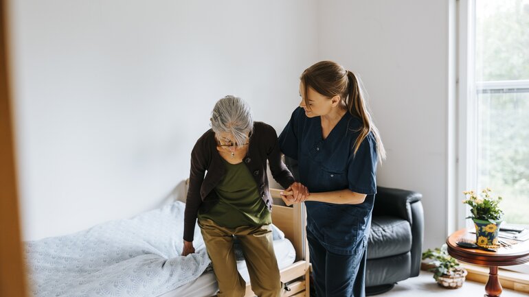 Pflegerin und ältere Frau in Pflegeeinrichtung