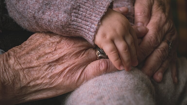 Kinderhände und Hände von älterer Person