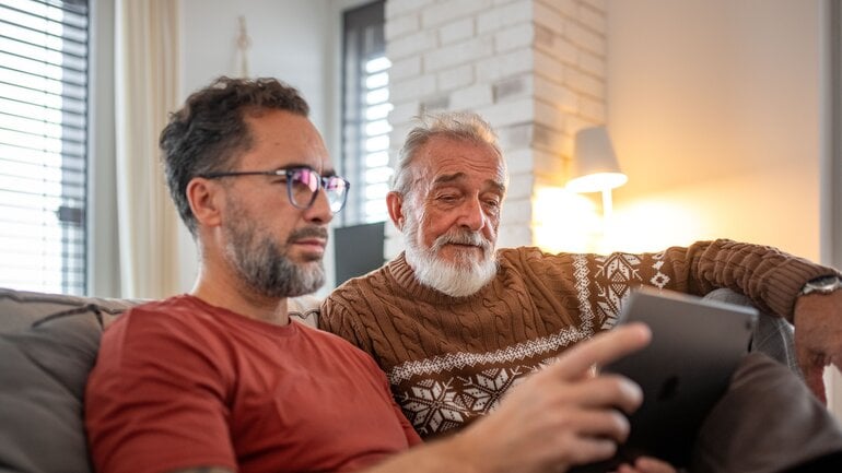 Mann und sein älterer Vater am Tablet