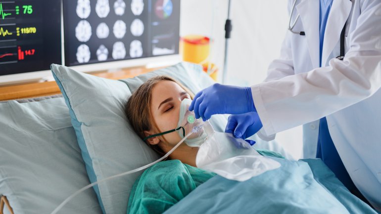 Eine Jugendliche liegt im krankenhausbett, ein Arzt setzt ihr eine Sauerstoffmaske auf