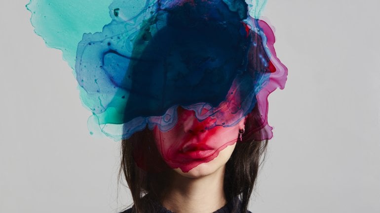 Eine Frau mit einer Farbwolke über dem Kopf.