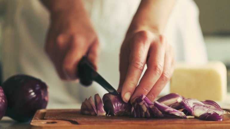 Eine Frau schneidet Zwiebeln.