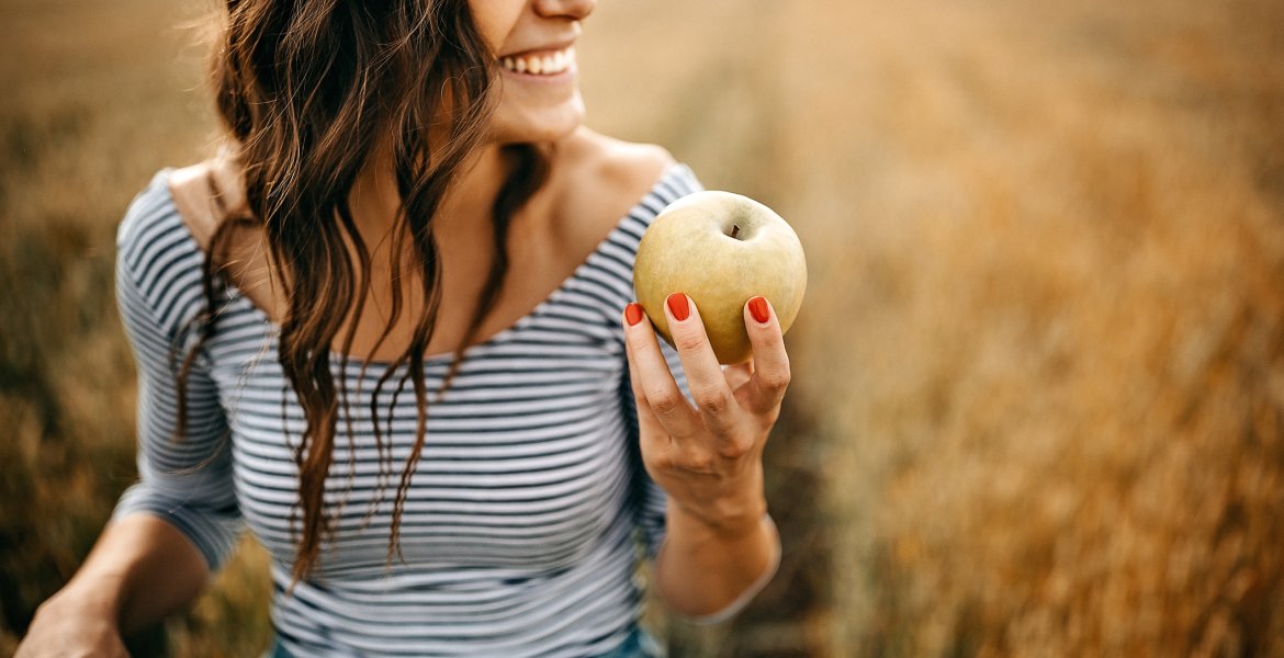 Eine Frau mit einem Apfel auf einem Feld