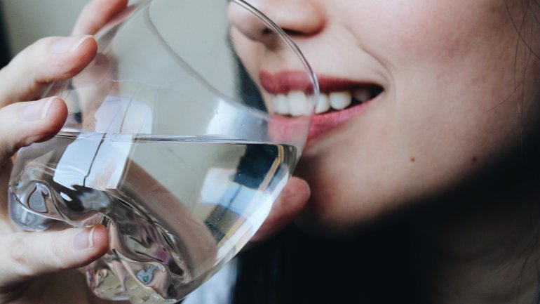 Eine Frau trinkt ein Glas wasser.
