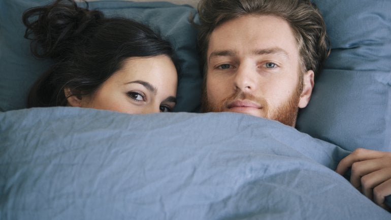 Man und Frau liegen im Bett