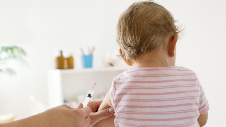 Ein Baby bekommt eine Impfdosis in den Oberarm gespritzt.