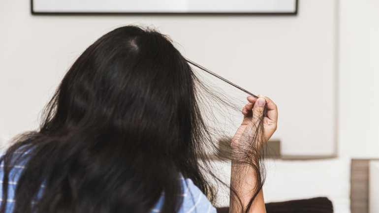 Trichotillomanie: Eine Frau reißt sich Haare aus.