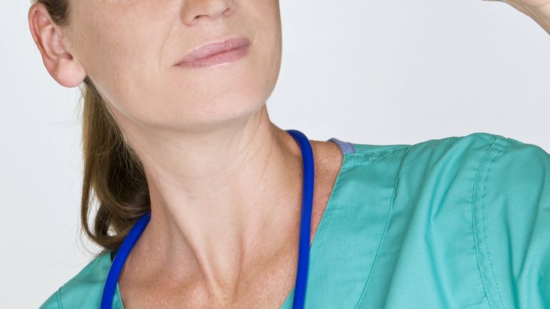 Das Bild zeigt eine Krankenschwester, die eine Urinprobe in der Hand hält. 