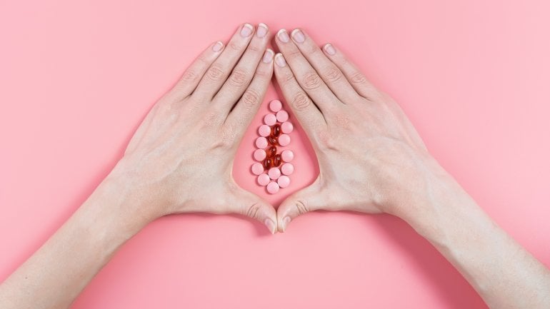 Eine nachgebildete Vagina aus Perlen auf einem rosa Hintergrund.