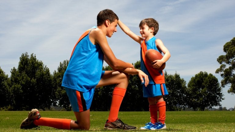 Das Bild zeigt ein Kind mit einem Football in der Hand.