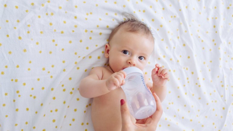 Ein Baby bekommt Wasser aus der Nuckelflasche zu trinken.