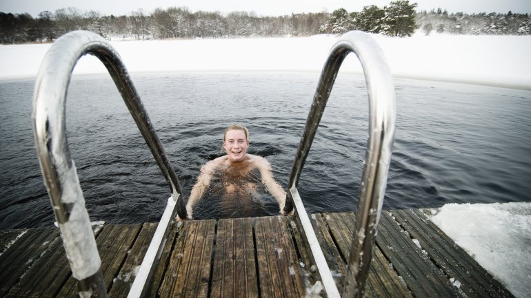 Ein Mann badet in einem eiskalten See.