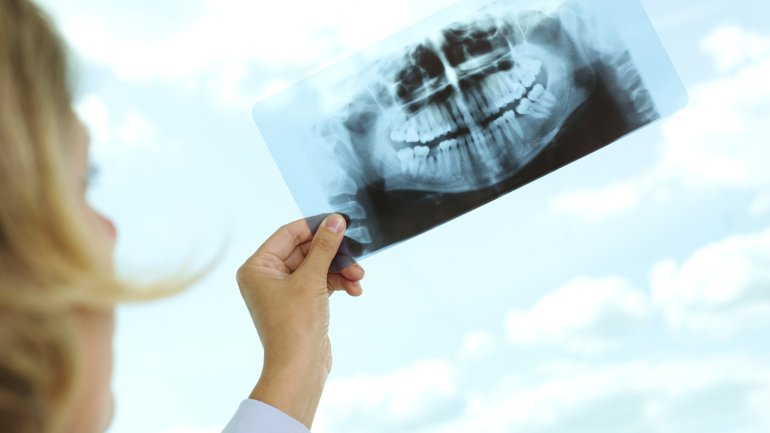 Eine Zahnärztin betrachtet ein Röntgenbild.