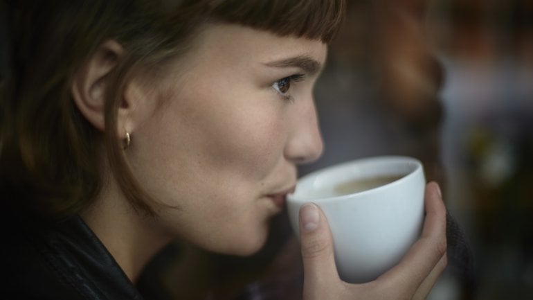 Zunge verbrannt: Frau trinkt eine Tasse Tee